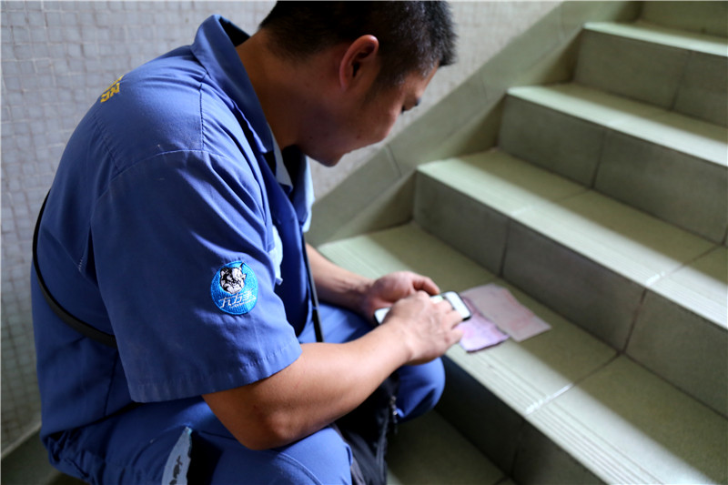 客戶還是沒有到，家具安裝謝師傅蹲在門口等，一邊等一邊處理今天要去的下一家客戶的資料