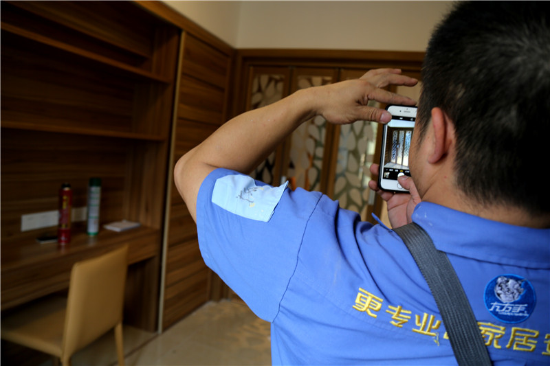 謝師傅看著安裝好的家具，拍下照片