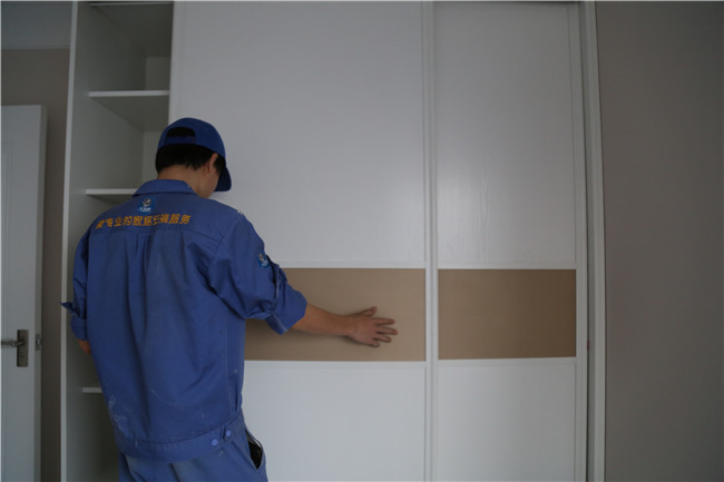 家具安裝工正在現(xiàn)場進(jìn)行實木衣柜維修工作